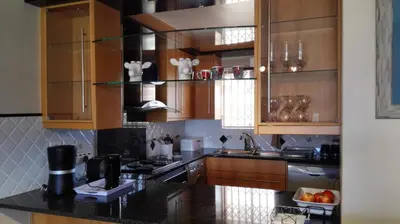 a kitchen with wooden cabinets and a black counter top at Emerald Bay in Strand