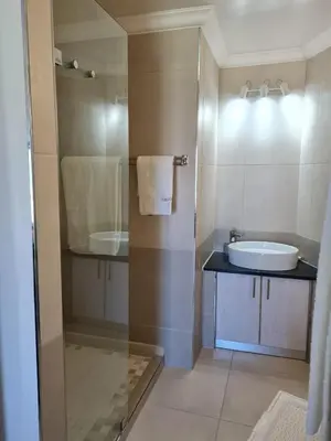 a bathroom with a sink and a glass shower at Emerald Bay in Strand