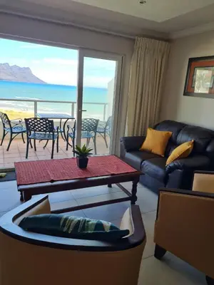 a living room with a couch and a table at Emerald Bay in Strand