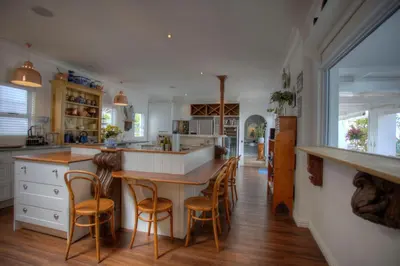 a kitchen with a large island with bar stools at Our Hermanus House in Hermanus