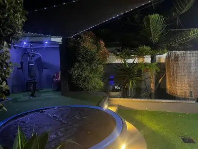 a swimming pool in a garden at night at Mitchell's Guesthouse in Parow