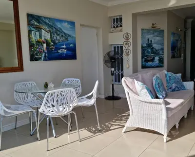 a living room with a table and chairs and a couch at 'The View' on Bikini Beach, Seafront, 2 bedroom, Sleeps 4 in Gordonʼs Bay