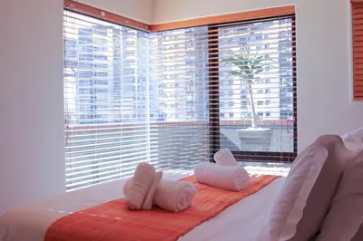 a bedroom with a bed and a large window at Manhattan Luxury Suite at Canal Walk in Cape Town