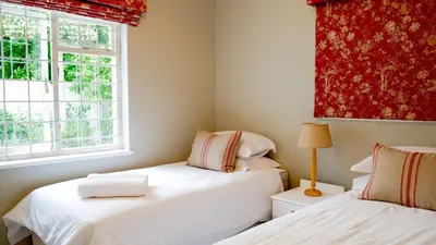 a room with two beds and a window at Laurel Cottage in Franschhoek