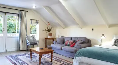 a living room with a bed and a couch at Laurel Cottage in Franschhoek