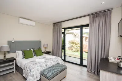 a bedroom with a bed and a large window at Du Kloof Lodge in Paarl