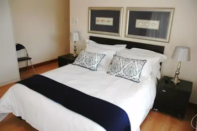 a bedroom with a large white bed with pillows at Edelweiss Bed & Breakfast in Stellenbosch