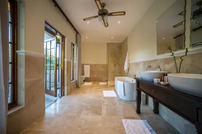 a bathroom with two sinks and a large mirror at Boutique Villa Guesthouse in Somerset West