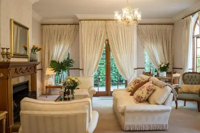 a living room with a couch and chairs and a chandelier at Boutique Villa Guesthouse in Somerset West