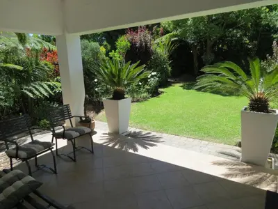 a patio with two chairs and palm trees at 10 Kommandeurs Ave, Stellenbosch in Stellenbosch