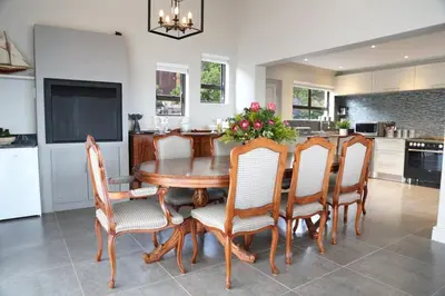 a kitchen with a dining room table and chairs at Proteus Beach House in Rooiels