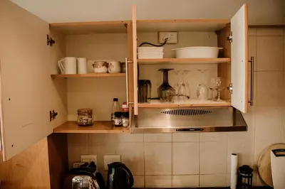 a kitchen with an open cabinet with utensils at Concord Apartment in Stellenbosch