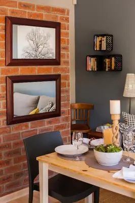 a dining room with a table and a brick wall at Treehouse at Theebos in Strand