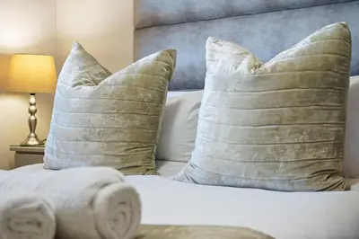 a bed with two pillows and a headboard with a bed with at Dolphin Beach H106 in Bloubergstrand