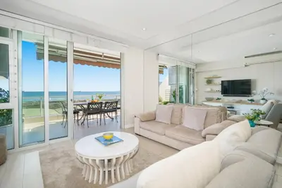 a living room with a couch and a table at Dolphin Beach H106 in Bloubergstrand