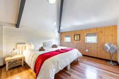 a bedroom with a large bed with a teddy bear on it at Trail's End in Elgin