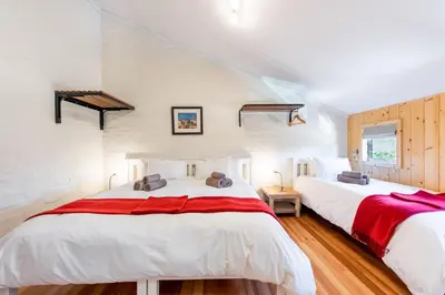 two beds in a room with white walls at Trail's End in Elgin