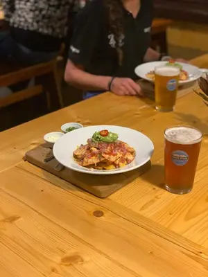 a table with two plates of food and two glasses of beer at Trail's End in Elgin