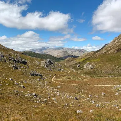 a dirt road in a field with mountains in the background at Trail's End in Elgin