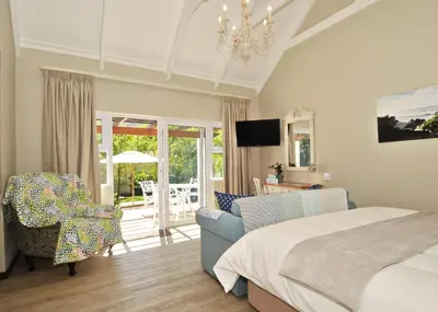 a bedroom with a bed and a living room at The Gables Hermanus in Hermanus