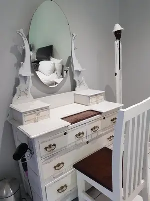 a white dressing table with a mirror and a bed at Zonnevanger Guesthouse in Noorder-Paarl