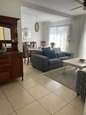 a living room with a couch and a table at On Broadwalk Cottage in Cape Town