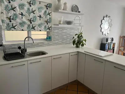 a kitchen with white cabinets and a sink at On Broadwalk Cottage in Cape Town