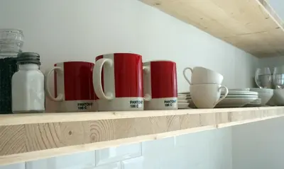 a shelf with cups and plates on it at No. 9 Keurboom in Cape Town