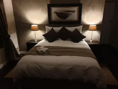 a bedroom with a large bed with two lamps at Guest House Frame Ace in Bellville