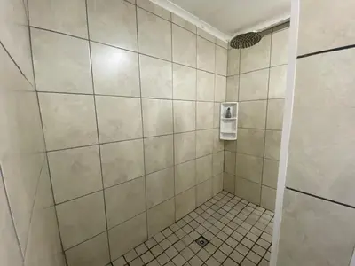 a bathroom with a shower with white tiles at Willows Curve in Somerset West