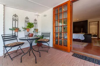 a room with a table and two chairs and a door at The Garden View Suite in Franschhoek