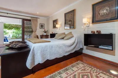 a bedroom with a large bed and a television at The Garden View Suite in Franschhoek