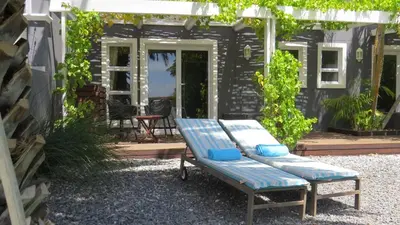 a blue bench sitting on a gravel patio at Bloemenzee Boutique B&B in Gordonʼs Bay