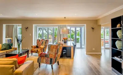 a living room with a table and chairs at Bloemenzee Boutique B&B in Gordonʼs Bay