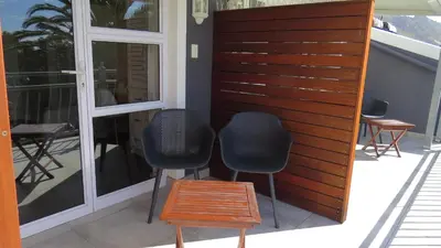 two chairs and a table on a patio at Bloemenzee Boutique B&B in Gordonʼs Bay