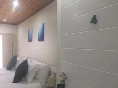 a bedroom with a bed and three paintings on the wall at Paarl Mountain Lodge in Paarl
