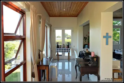 a living room with a table and windows at Paarl Mountain Lodge in Paarl