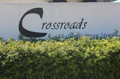 a sign for tossos floor strategies at Crossroads Guestrooms in Gordonʼs Bay
