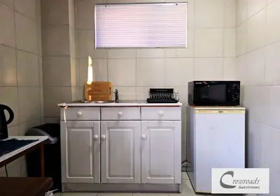 a kitchen with a microwave and a small refrigerator at Crossroads Guestrooms in Gordonʼs Bay