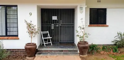 a front door of a house with a chair on the porch at 9 on Drommedaris in Stellenbosch
