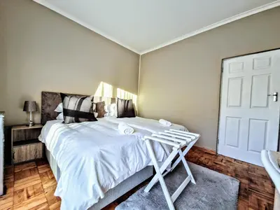 a bedroom with a bed with white sheets at 9 on Drommedaris in Stellenbosch