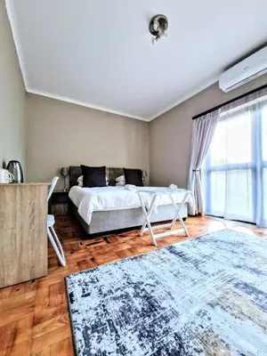 a bedroom with a bed and a large window at 9 on Drommedaris in Stellenbosch