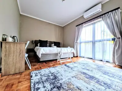 a bedroom with a bed and a large window at 9 on Drommedaris in Stellenbosch