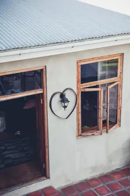 two windows and a mirror on the side of a building at Station House Simondium in Simondium