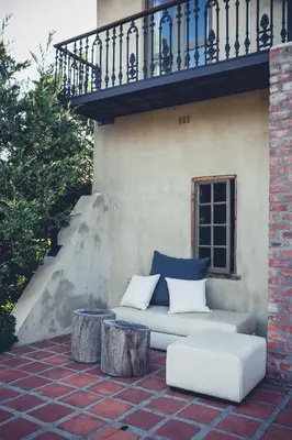 a couch sitting on a patio with a balcony at Station House Simondium in Simondium