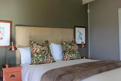 a bedroom with a large bed with two pillows at Cheverells Farm, Kiku & Braeburn Cottage in Grabouw
