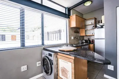 a kitchen with a washer and dryer on a counter at Avemore Eikehoff No 26 full power back up in Stellenbosch