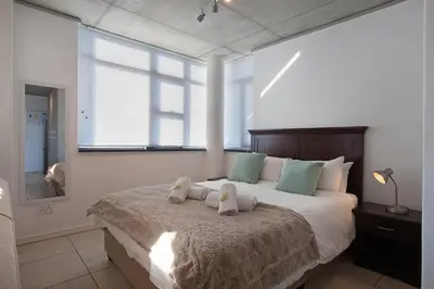 a bedroom with two stuffed animals on a bed at Key West 417 by CTHA in Cape Town