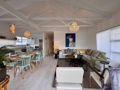 a living room with a couch and a table at Beach House by Beach Collection Winelands in Strand