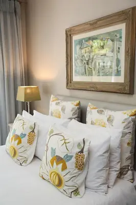a bed with white pillows and a picture on the wall at 5 Konings Guesthouse in Paarl
